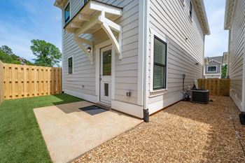A townhouse with a wooden fence and a green lawn at Turnberry Park Luxury Rental Homes in Gardendale, AL